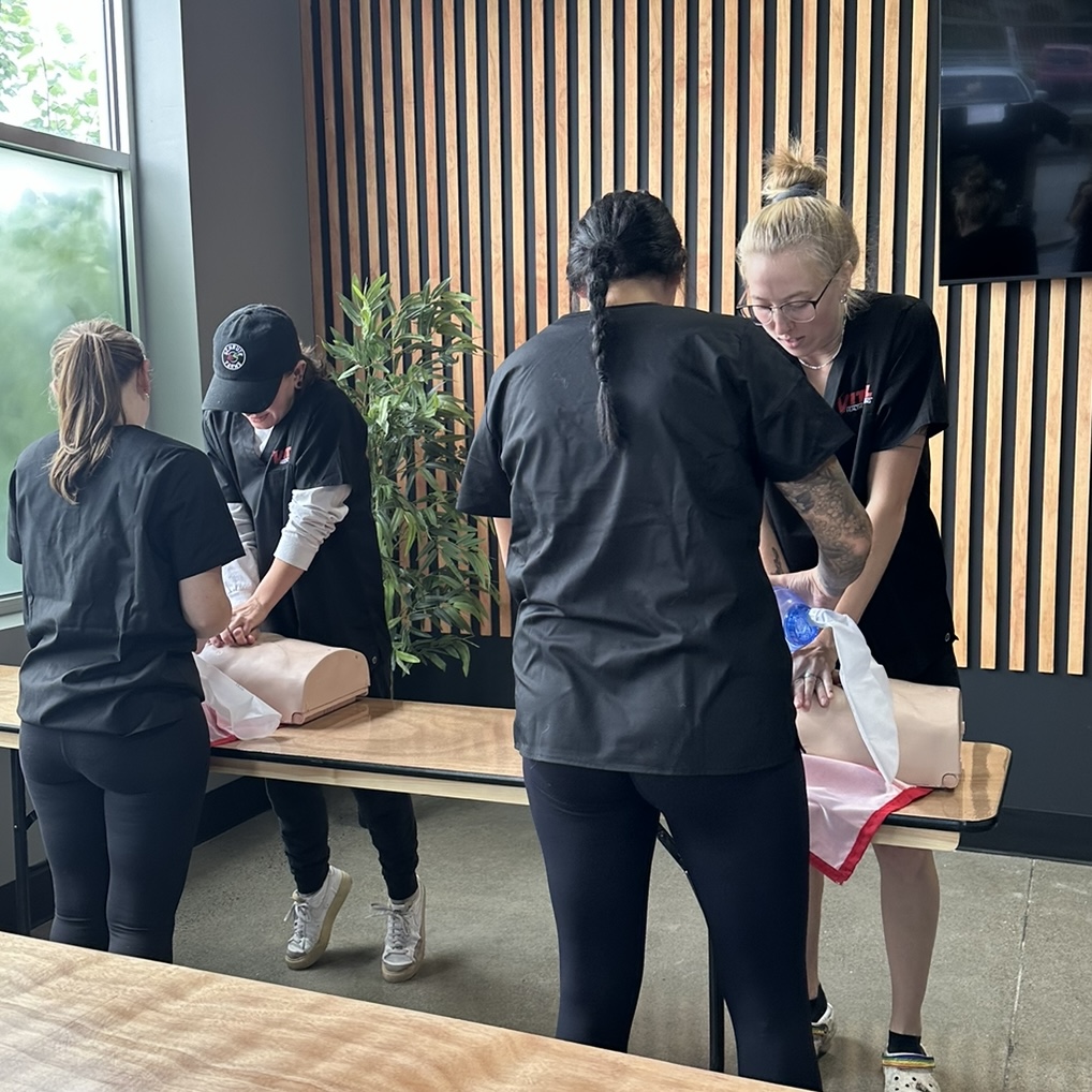 Four individuals wearing the uniform of Vital Healthcare Training